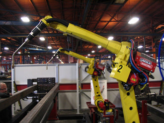 Industrial robot arms on a factory line representing broader multi-industry robotics demand