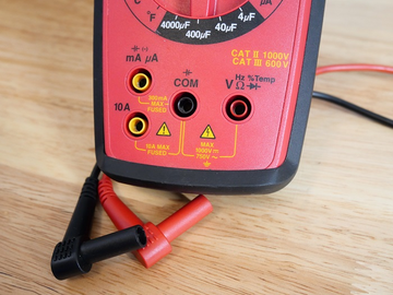 Digital multimeter leads positioned for industrial voltage measurement