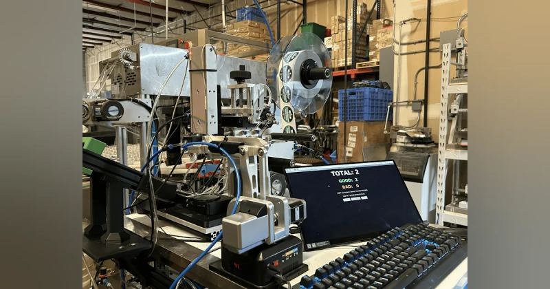 AlgaeBarn in-house cap labeling cell with label spool and vision quality counters